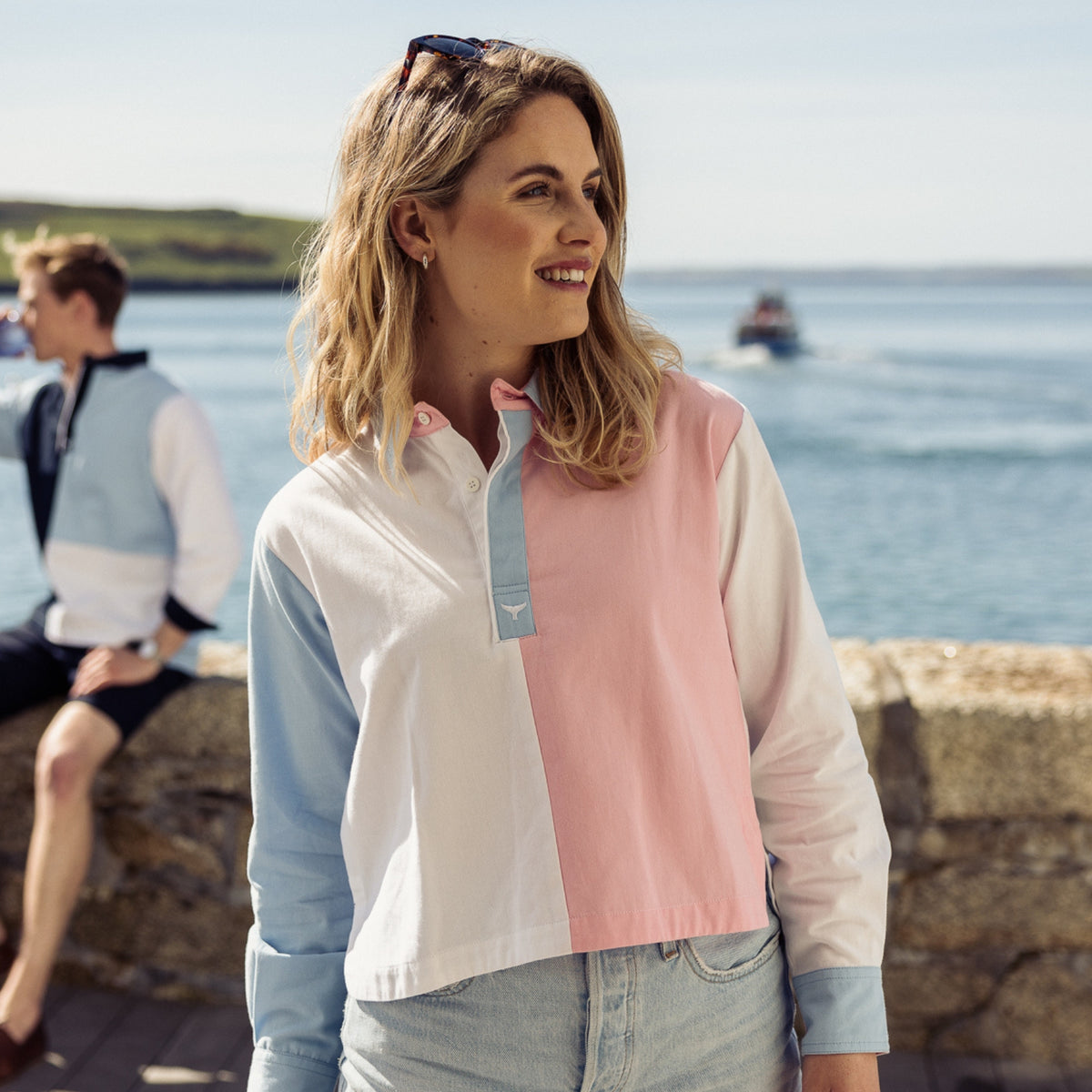Female model standing on the Cornish coast wearing our Whitecliff Cropped Deck Shirt with the sea in the background.
